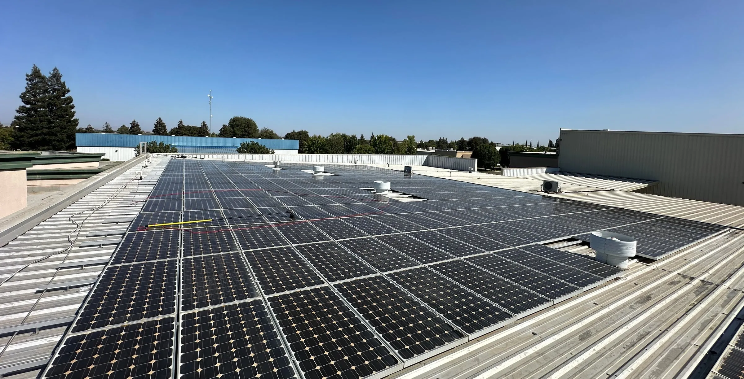 Large commercial rooftop solar array with clean, dark panels